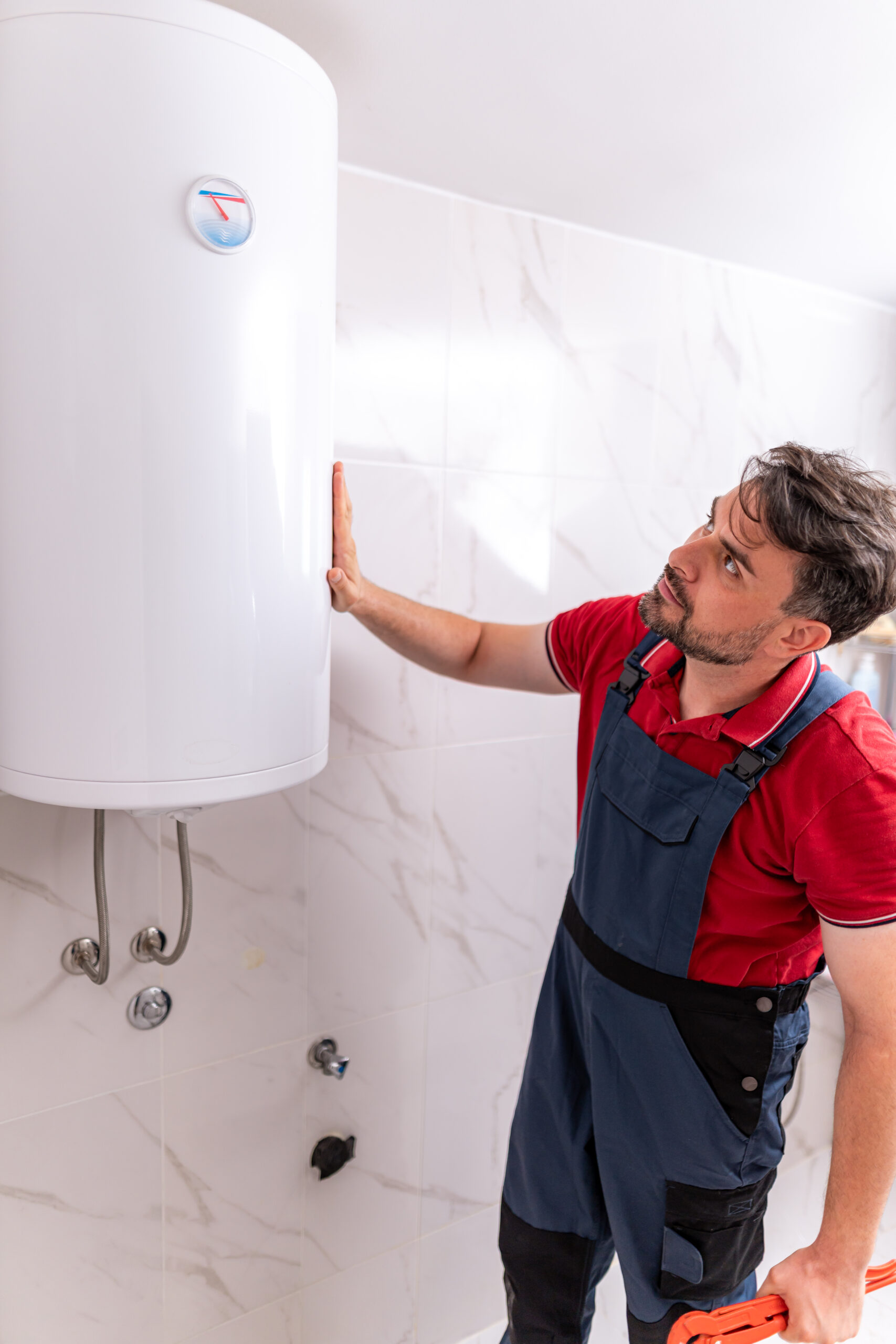 Repairing a water heater in a modern bathroom during the day